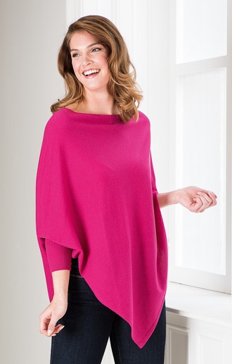 smiling model in bright pink merino poncho