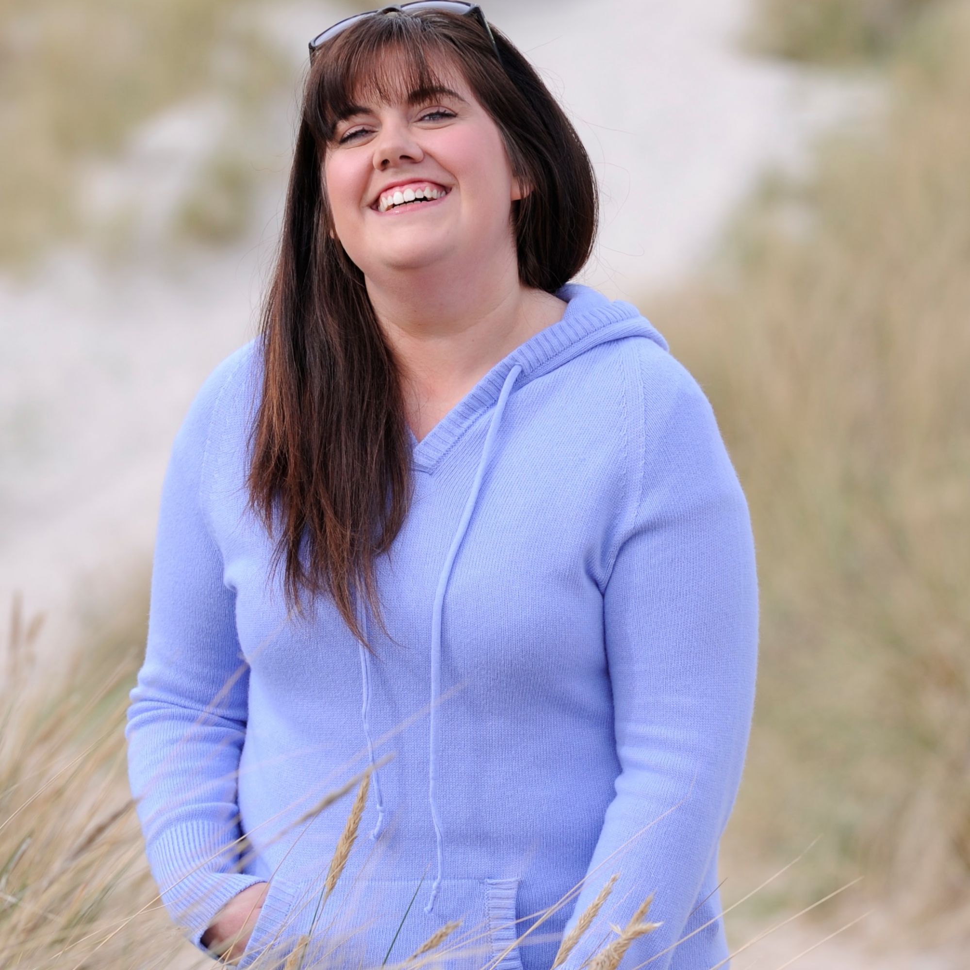 buyer wearing cashmere hooded top in sand beach