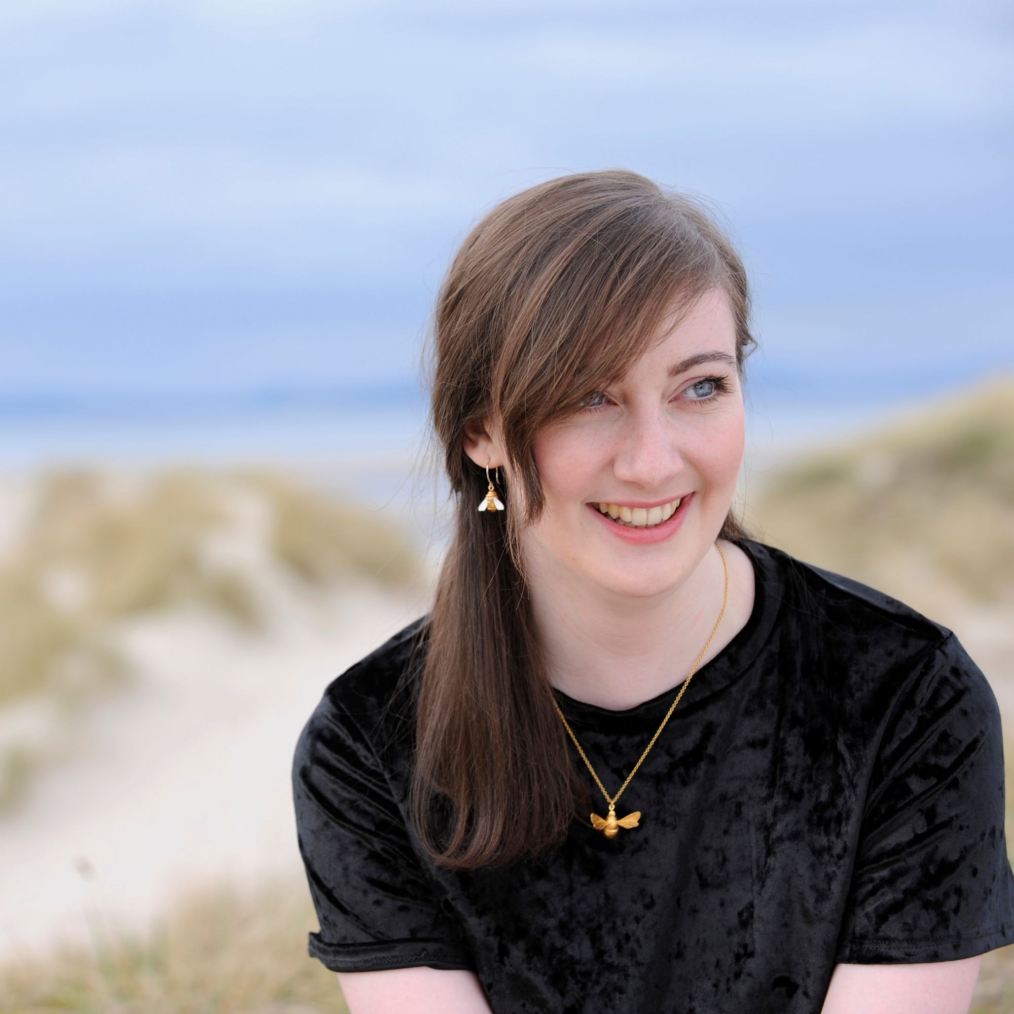 buying wearing bee necklace in sand beach
