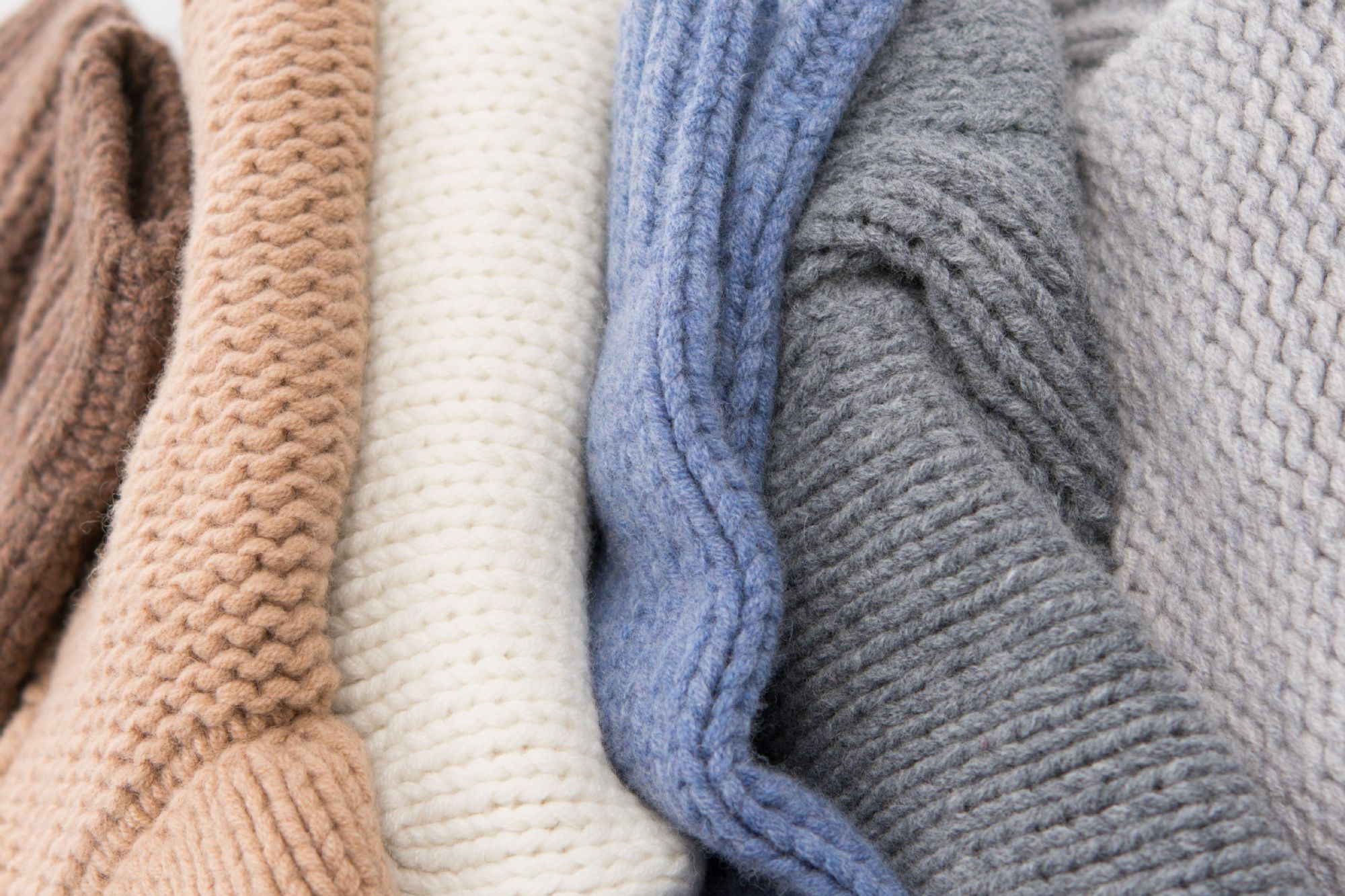 Stack of lambswool chunky knitwear in range of neutral colours