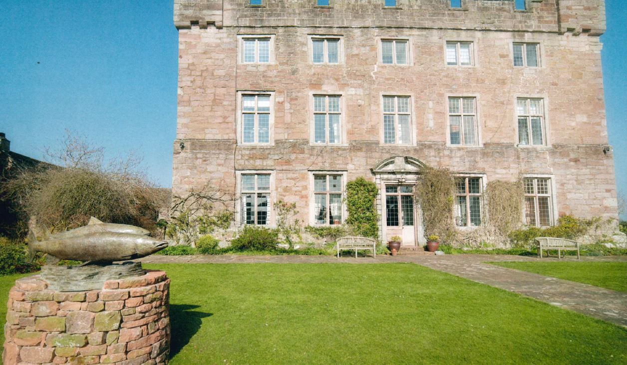 country mansion with salmon sculpture outside on grass